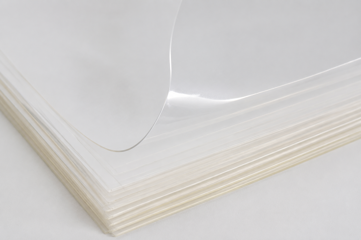 Colorless clear PET film sheets with precise cut edges and a gently curved top sheet